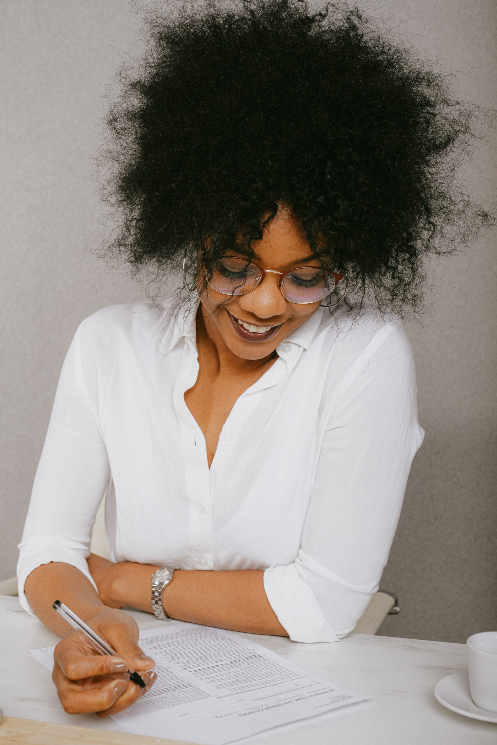 Professional woman smiling and reviewing paperwork. 