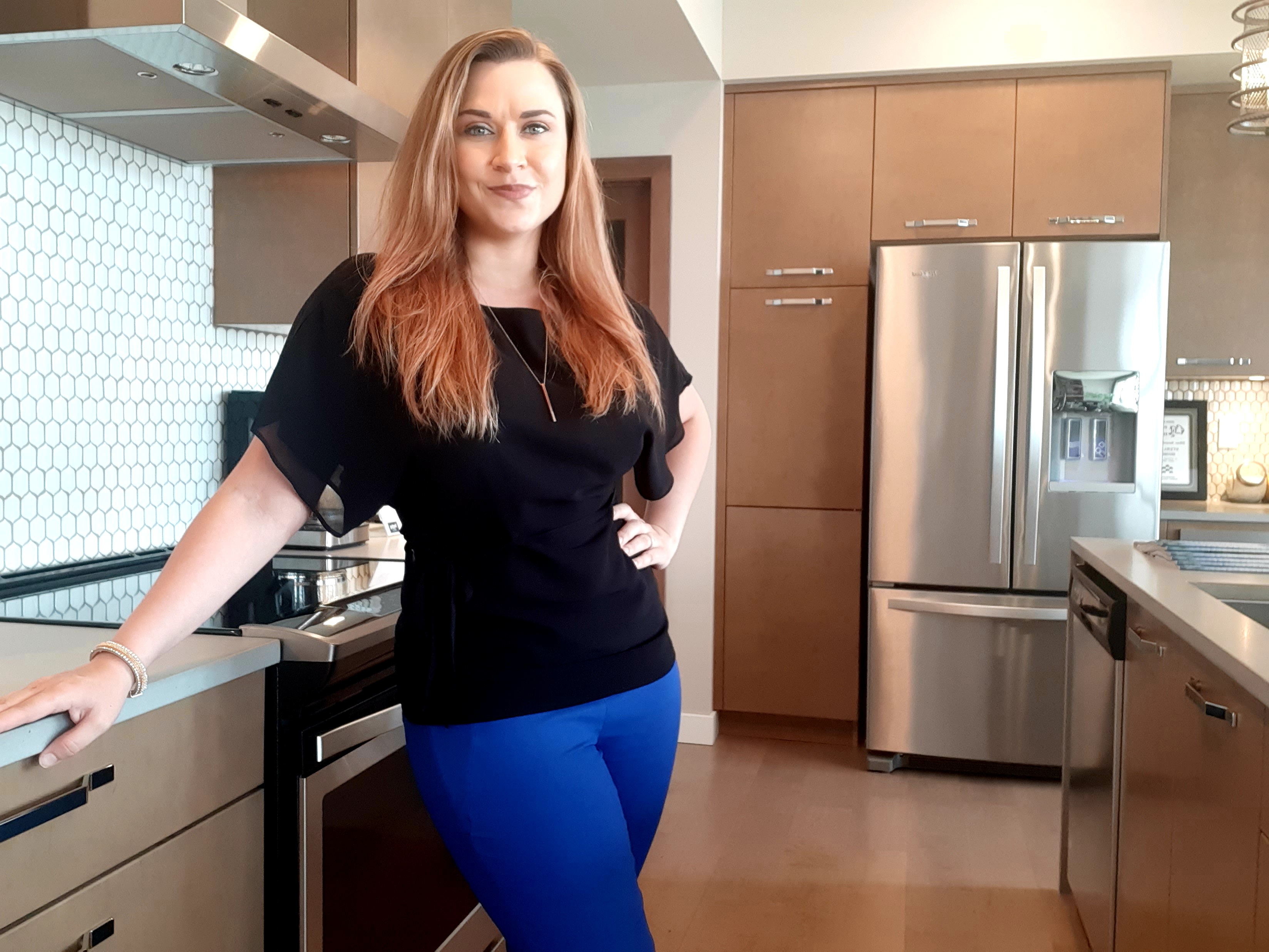 Courtney standing in the kitchen of a new home. 