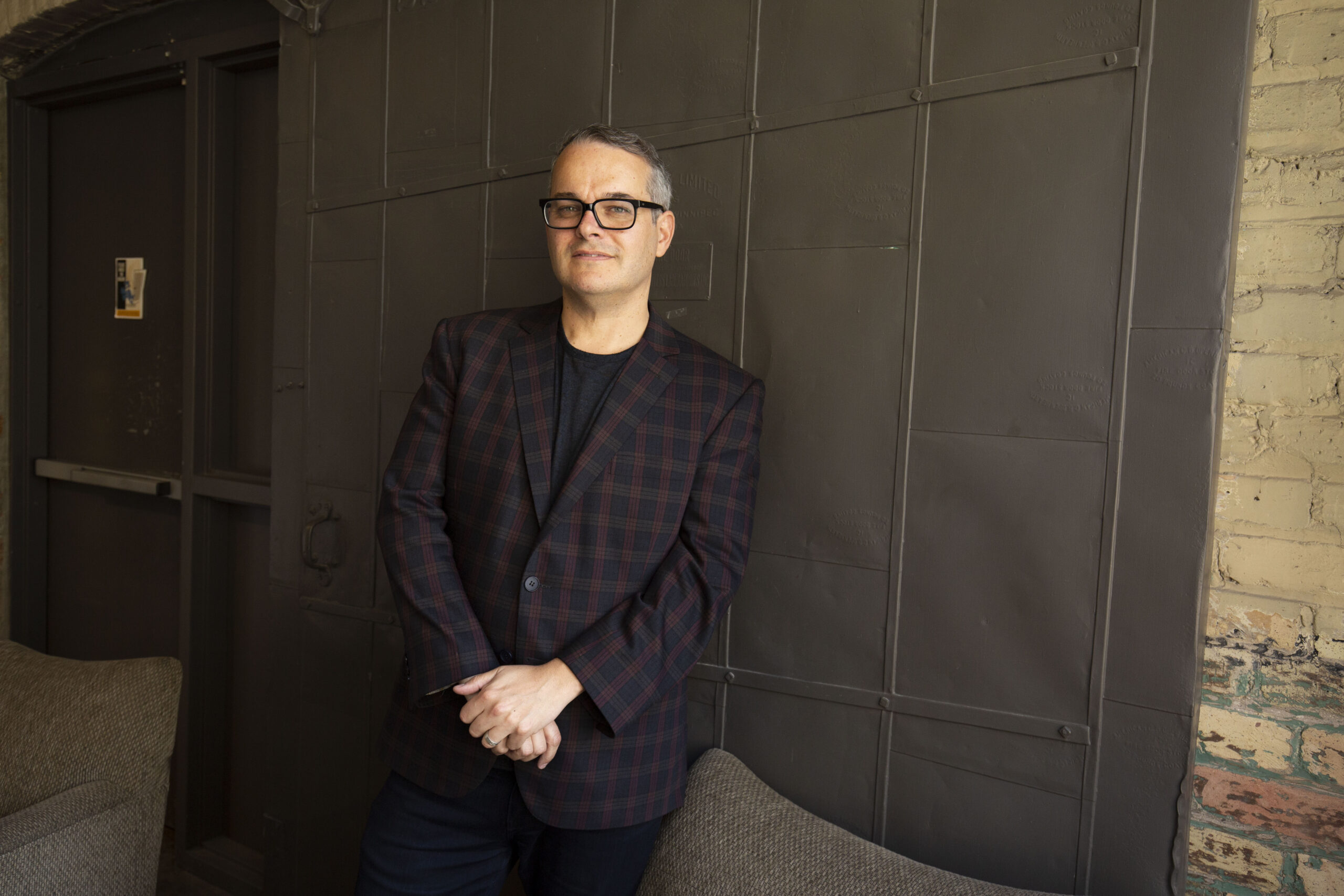 Stephen Brown, CM and marketing leader, standing in front of wall. 