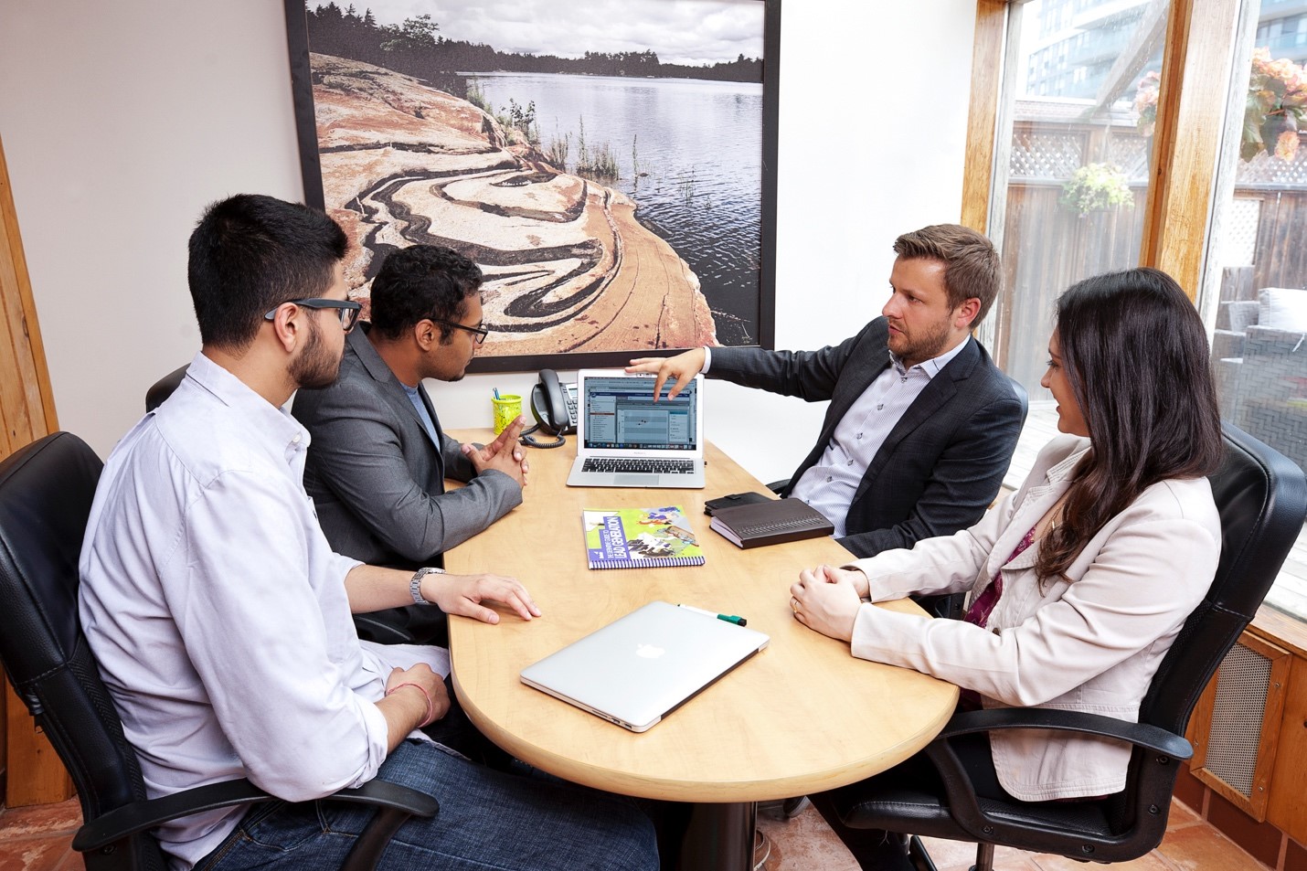 Dan Radu, CM and martech specialist, sitting in board room with colleagues.